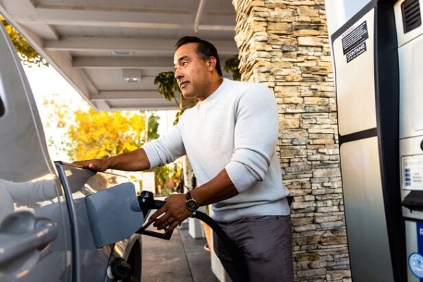 A fleet driver fueling his company truck at a gas station.