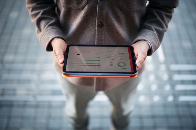 A fleet owner reviews fuel card usage of his drivers on a tablet.