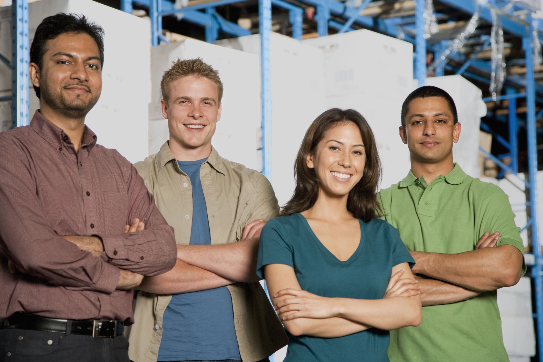A young team of fleet drivers stand together outside the warehouse where they work.