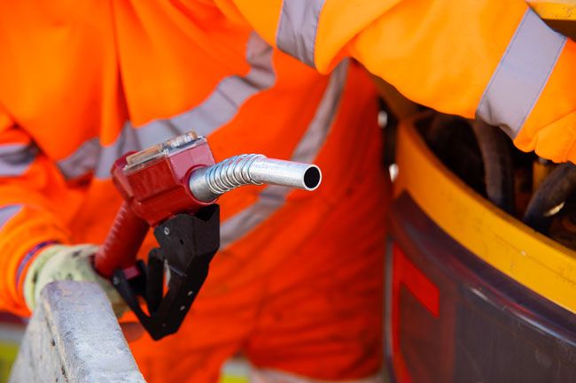 A construction worker fuels his vehicle with a fleet fuel card.