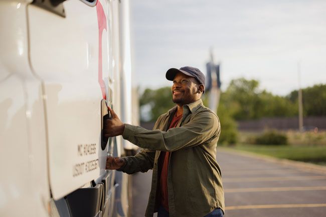 A fleet driver prepares to fuel up his semi truck with fuel at a gas station using a fleet card.