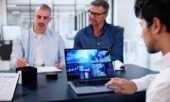 A business team reviews data on a laptop that shows real-time fuel card usage.