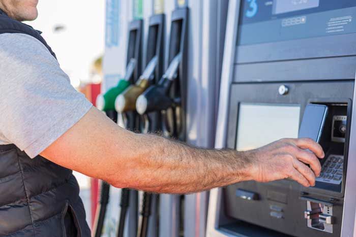 A fleet driver pays for his fuel with his phone at the pump.