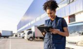 A fleet manager uses fuel card data to review efficiencies in real-time on her tablet outside her facility.