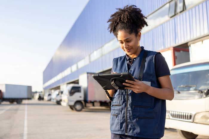 A fleet manager uses fuel card data to review efficiencies in real-time on her tablet outside her facility.
